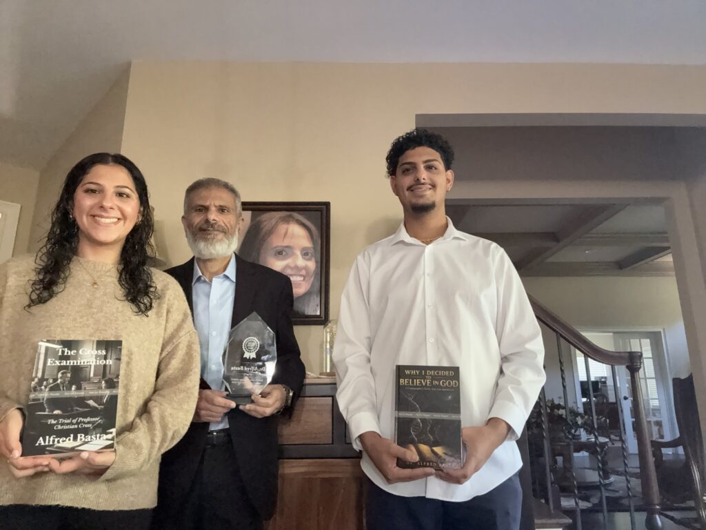 Alfred Basta holding the Best of Best Review 2026 award for Best Fiction Christian Author in the United States, flanked by family members holding his books The Cross Examination and Why I Decided to Believe in God